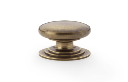 View Alexander & Wilks Waltz Round Cupboard Knob on Stepped Rose - Antique Brass - 32mm offered by HiF Kitchens